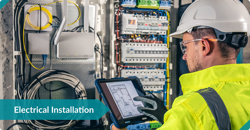 Monitor displaying IntelliBid software with LantroTech estimators analyzing material costs and labor hours for an electrical project.