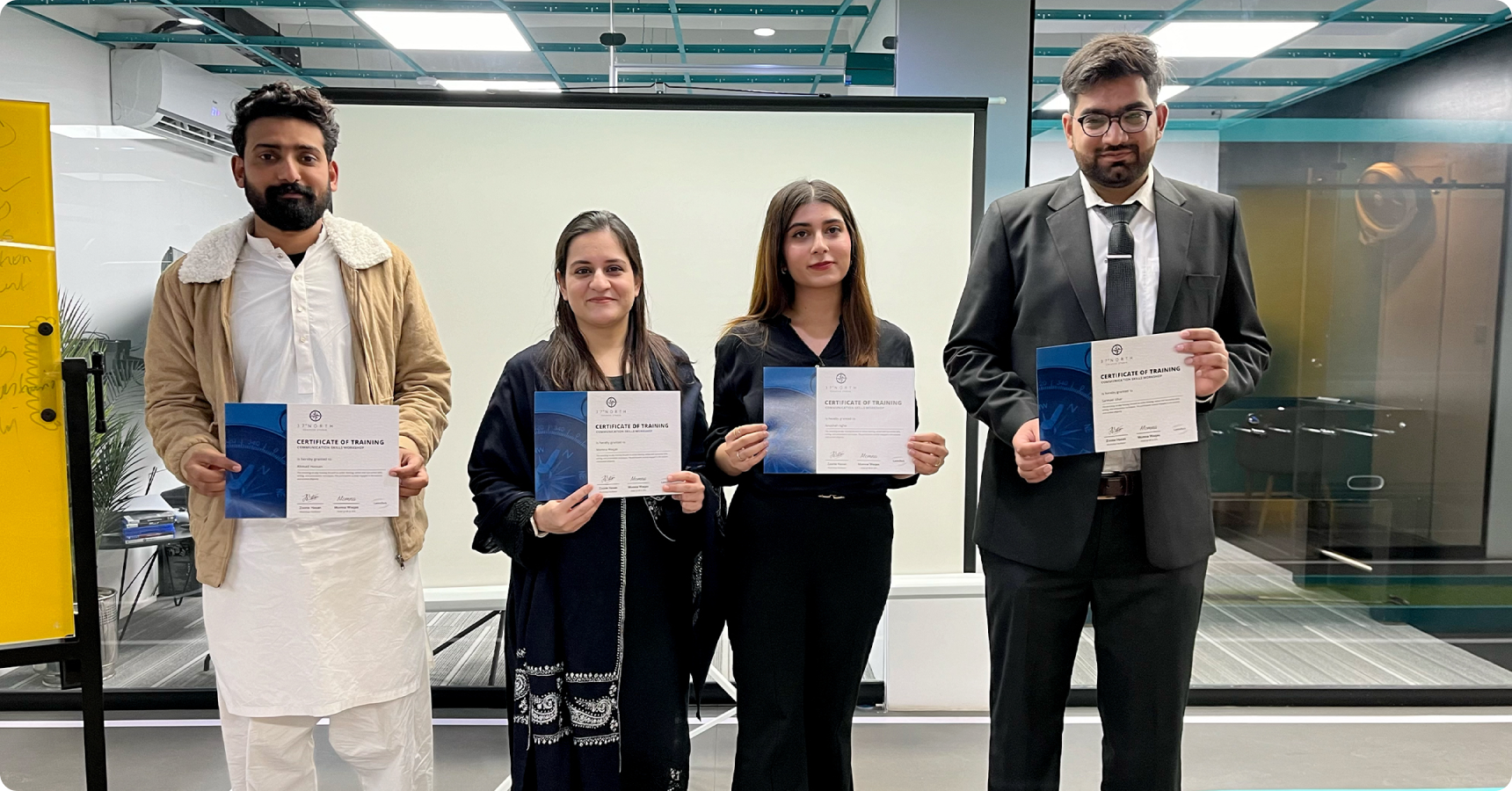 LantroTech employees proudly holding certificates after completing a communication workshop, showcasing growth and learning.