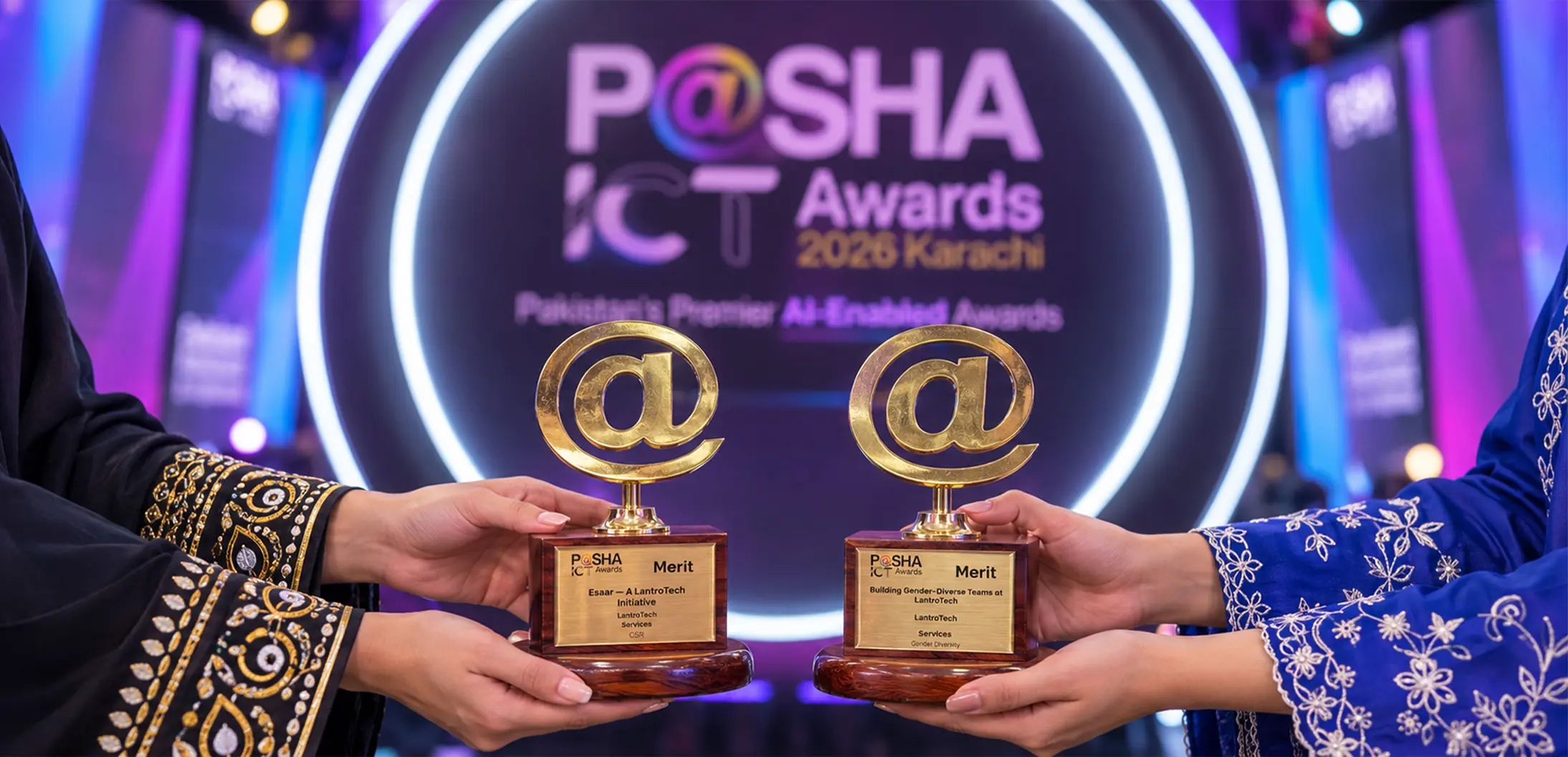 LantroTech representatives holding two Merit Award trophies at the P@SHA ICT Awards 2026 in Karachi, recognizing the company in the Gender Diversity and Corporate Social Responsibility categories.